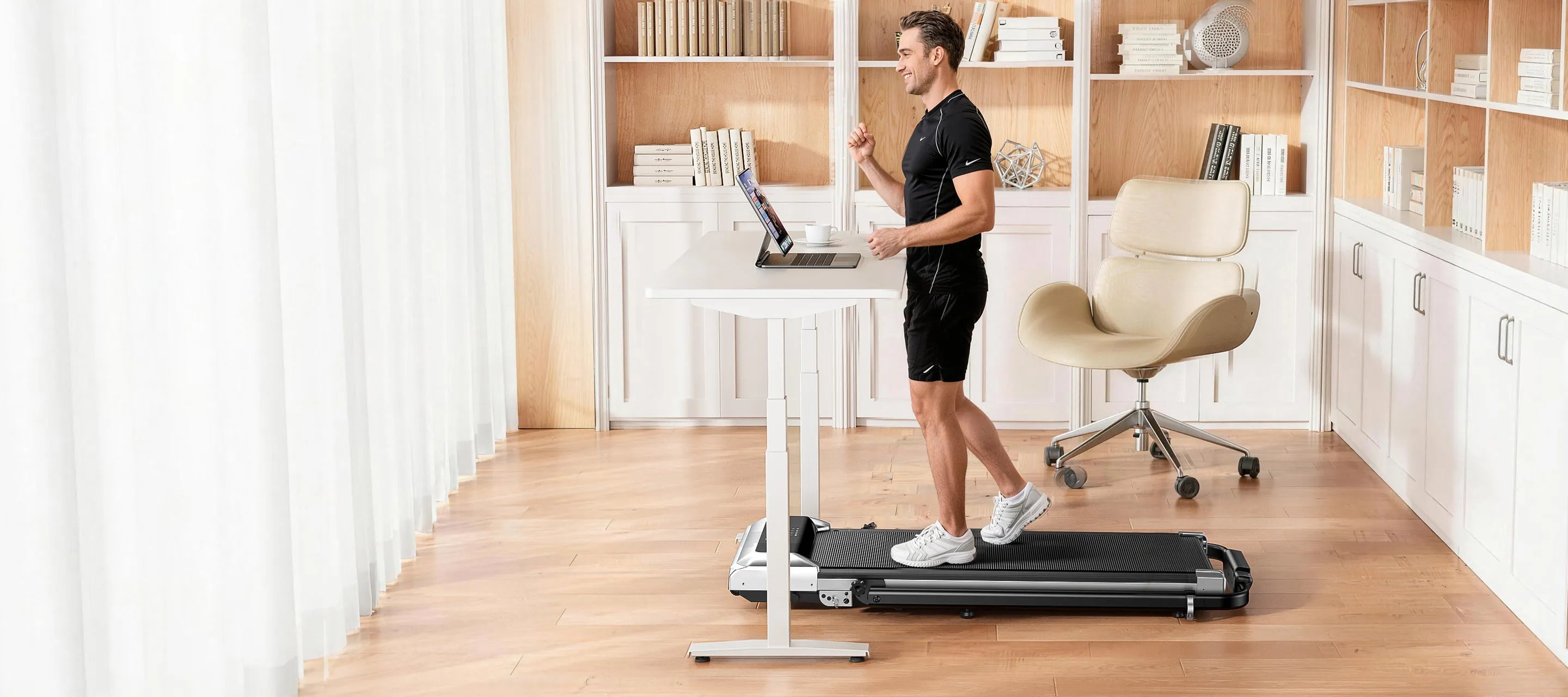 Male adult performing low-impact exercises using TP6 under-desk exerciser at his desk
