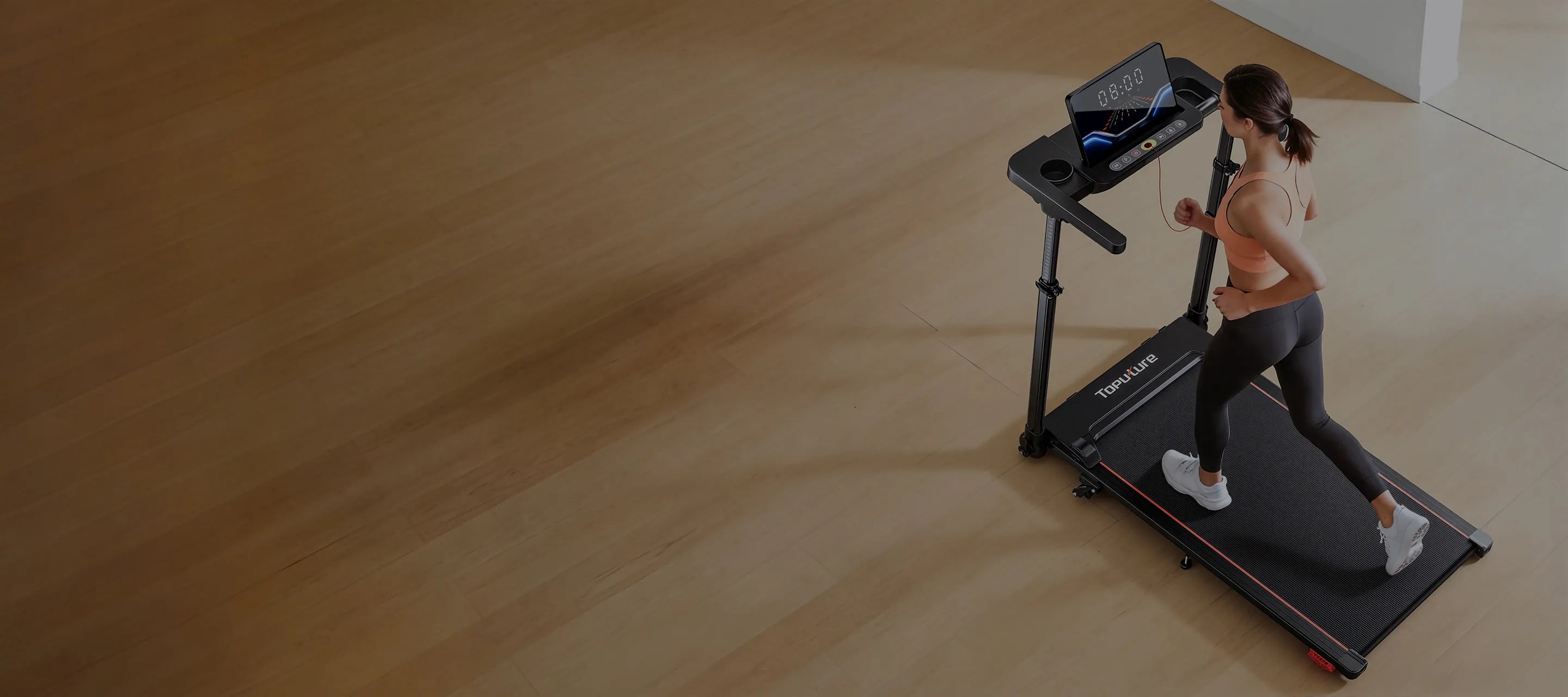 A woman running on a treadmill placed on wooden flooring at home, blending fitness naturally into her living space.