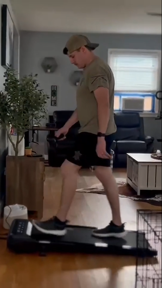 A man engaging in a powerful run on a sturdy home treadmill for cardio and endurance building in his living room.