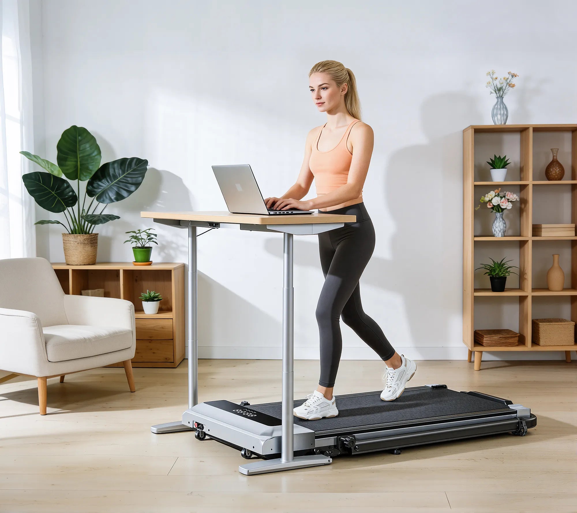 A woman walking on an under‑desk walking pad while working on her computer, integrating gentle movement into her focused workflow.
