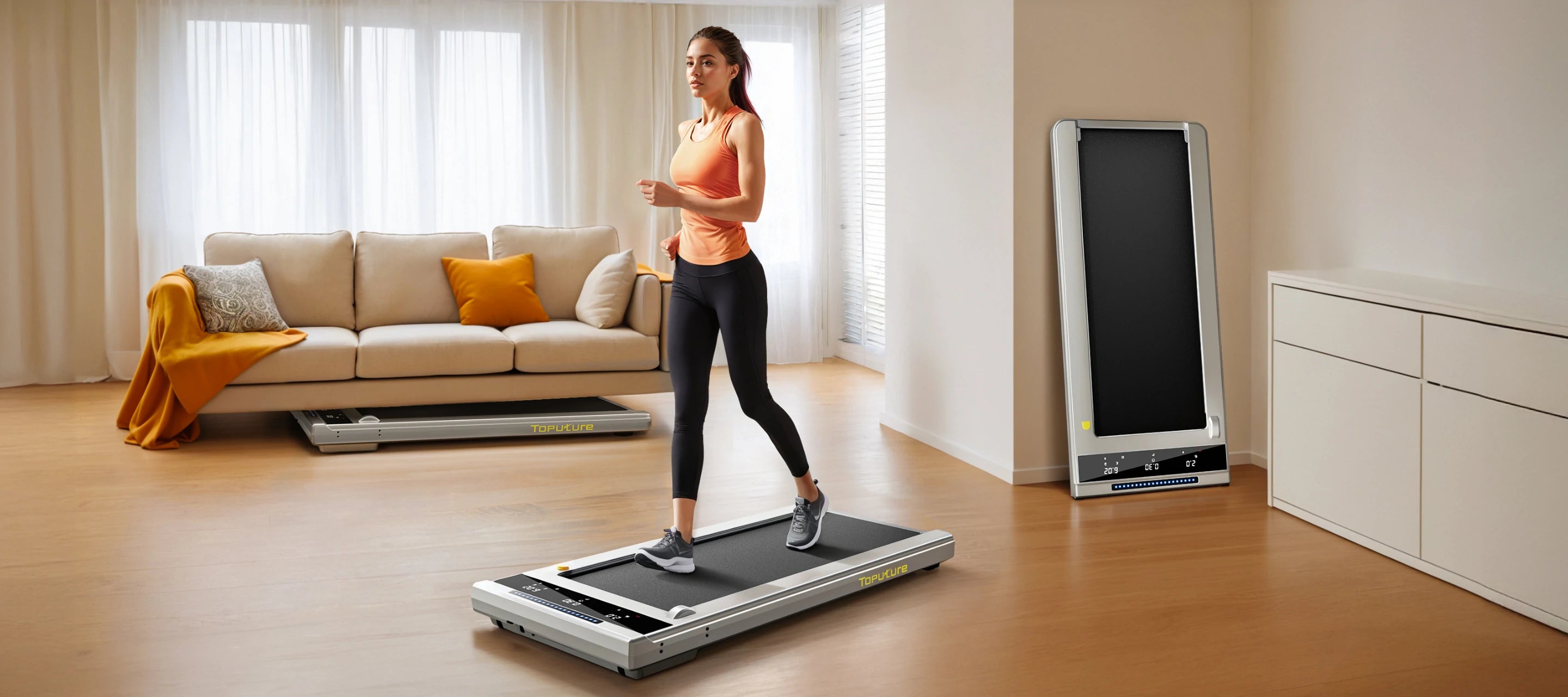 A woman walking on the compact Toputure walking pad, which tucks easily under the sofa or against the wall when not in use.